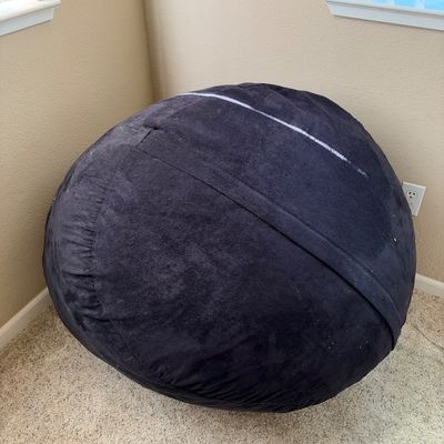Large black bean bag chair with a microfiber cover, set in the corner of a room.