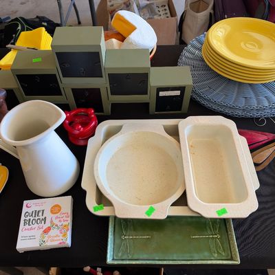Sale Photo Thumbnail #154: Collection of eclectic home decor and kitchen items, including a white ceramic pitcher, speckled baking dishes, yellow Fiesta-style plates, and a green dragonfly tray.