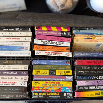 Sale Photo Thumbnail #167: Black nylon carrying case filled with a collection of vintage cassette singles from the late 1980s and 1990s.