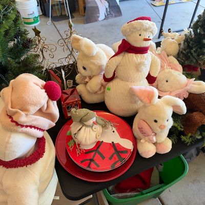 Sale Photo Thumbnail #126: Collection of holiday decorations, including plush snowmen, stuffed bunnies, miniature Christmas trees, and decorative red ceramic plates.