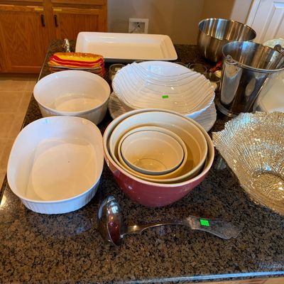 Collection of kitchenware and serving items including ceramic mixing bowls, baking dishes, a stainless steel ice bucket, a textured glass...