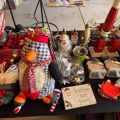 Sale Photo Thumbnail #130: Collection of holiday decorations, featuring a plush plush penguin wearing a red scarf, Santa figurines, stocking holders, and small decorative signs.