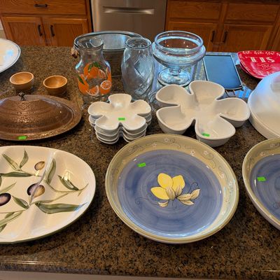 Collection of kitchenware and serving pieces, including lemon-themed ceramic platters, an olive-patterned divided dish, clear glass...
