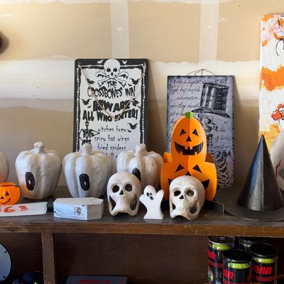 Sale Photo Thumbnail #146: Collection of Halloween decor items, including paper maché pumpkins spelling out 'BOO', skulls, a witch hat, and themed wall signs.