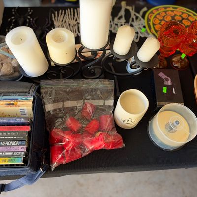 Sale Photo Thumbnail #166: Collection of home decor and media items, including pillar candles in wrought iron holders, cassette tapes in a case, red glassware, and a basket.