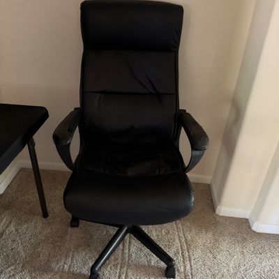 Contemporary black faux leather high-back executive office chair featuring padded armrests and a five-star caster base.