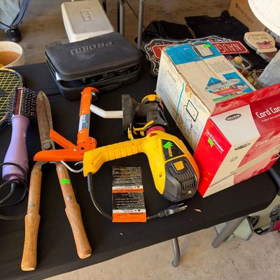 Sale Photo Thumbnail #119: Assortment of household and lawn tools including a yellow Wagner paint sprayer, wooden-handled hedge shears, an orange caulking gun, a purple hair dryer brush, and boxed Belkin cord concealer.