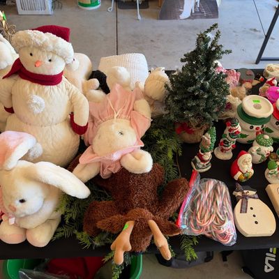 Sale Photo Thumbnail #127: Collection of holiday decorations, featuring plush snowmen and animals alongside ceramic Santa figurines, artificial mini trees, and candy canes.