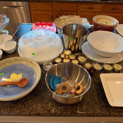Assortment of kitchen and serving ware including a stainless steel ice bucket, ceramic bowls, glass votive candle holders, and various...