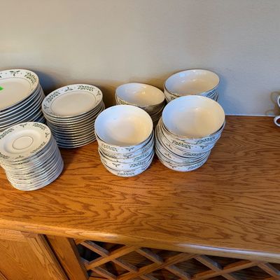 Large service set of vintage fine china with silver trim and a green floral vine motif, including stacks of dinner plates, salad plates,...