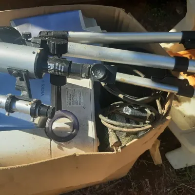 Silver Science Tech refractor telescope with adjustable tripod and accessories, stored inside a cardboard box.