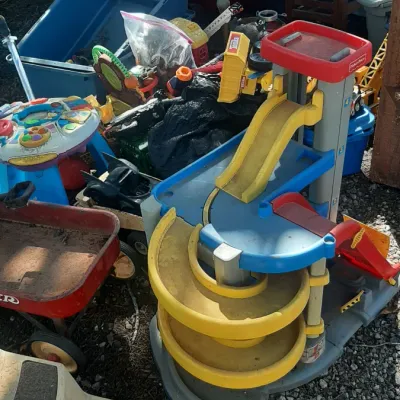 Collection of outdoor children's toys, including a Fisher-Price Little People garage playset, Radio Flyer wagons, and various...