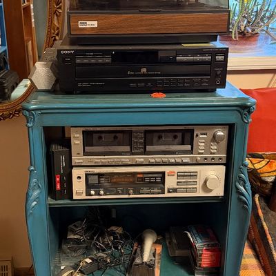 Vintage teal-painted wooden stereo cabinet filled with audio equipment, including a turntable, Sony CD player, Realistic double cassette...