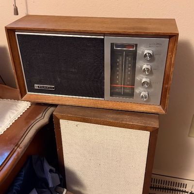 Vintage Panasonic solid-state AM/FM tabletop radio in a wood cabinet, resting atop a matching wood-cased speaker.