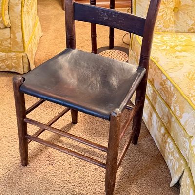 Vintage dark-stained wooden ladder-back side chair with a contoured wooden seat and turned legs.