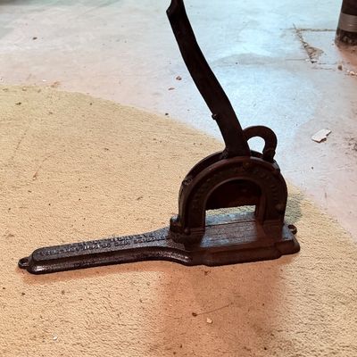 Antique heavy cast iron plug tobacco cutter with long lever handle and embossed lettering.