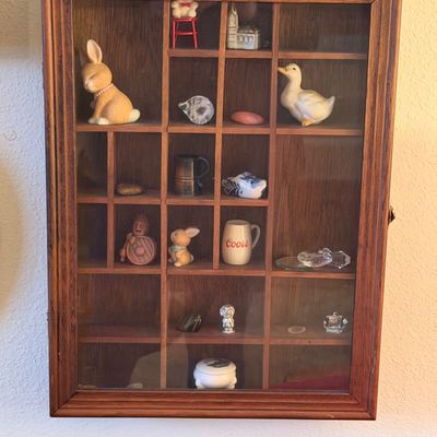 Vintage glass-front wooden shadow box shadowcase filled with various miniature trinkets, figurines, and collectibles.