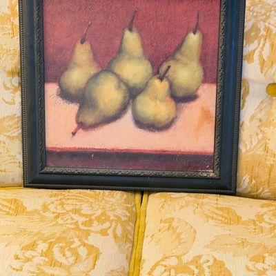 Framed still life print featuring five pears on a muted red background, set in a dark molded wooden frame.