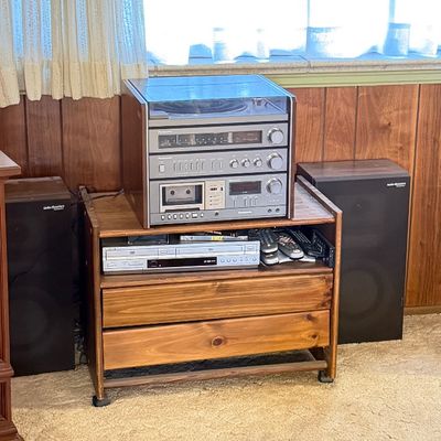 Vintage Panasonic stereo system with record player, cassette deck, and tuner housed in a wood-look cabinet, accompanied by a DVD player...