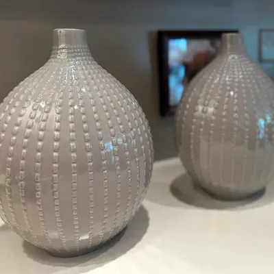 Sale Photo Thumbnail #62: Pair of contemporary light gray glazed ceramic bulbous vases featuring raised beaded vertical line texture.