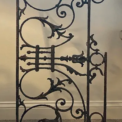 Sale Photo Thumbnail #237: Antique wrought iron architectural panel with ornate scrollwork and leaf details, displaying significant surface rust and patina.