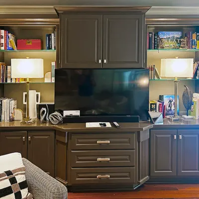 Sale Photo Thumbnail #63: Large dark grey built-in entertainment unit featuring custom shelving, cabinet storage, drawers, and integrated accent lighting.