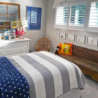 Sale Photo Thumbnail #19: Child's bedroom suite featuring a white-painted dresser with a windowpane mirror, a rustic wooden bench, and a bed with blue and grey bedding.