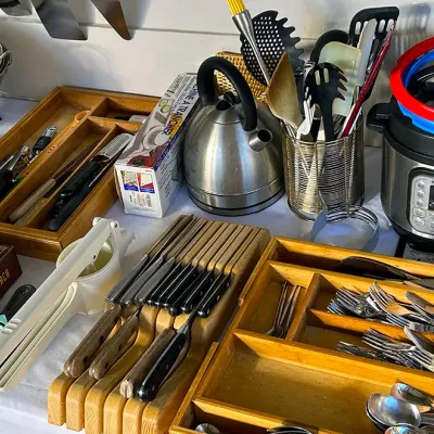Sale Photo Thumbnail #264: Collection of modern kitchenware, including an Instant Pot electric pressure cooker, a stainless steel tea kettle, a knife block set, wooden drawer organizers with flatware, and various cooking utensils.