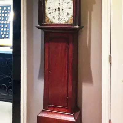 Sale Photo Thumbnail #98: Antique mahogany grandfather clock featuring a painted floral dial with Roman numerals and crazed glass detail.