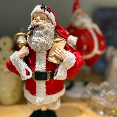 Sale Photo Thumbnail #89: Vintage-style Santa Claus figurine featuring a textured beard, smoking pipe, bell, and toy sack in a fabric suit.