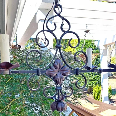Sale Photo Thumbnail #296: Vintage wrought iron chandelier featuring decorative scrollwork and a central leaf motif.