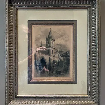 Sale Photo Thumbnail #97: Framed architectural drawing featuring a church steeple and village scene, double-matted in an ornate silver-finished molded frame.