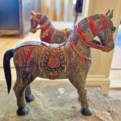 Sale Photo Thumbnail #231: Hand-carved and painted wooden horse figures in an Indian or South Asian folk art style, featuring distressed finish and intricate tack detailing.