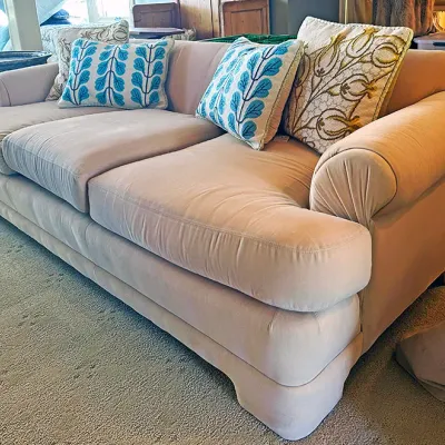 Sale Photo Thumbnail #108: Plush light pink sofa with rolled arms, featuring three seat cushions and styled with four decorative throw pillows with botanical embroidery.