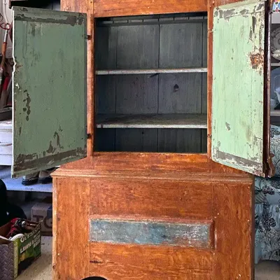 Sale Photo Thumbnail #271: Rustic antique wooden armoire cabinet featuring a warm stain exterior with distressed green-painted door interiors and shelving.