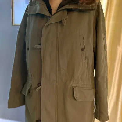 Sale Photo Thumbnail #167: Vintage olive green military-style parka coat featuring a faux-fur trimmed hood, front flap pockets, toggle closures, and a full zip front.