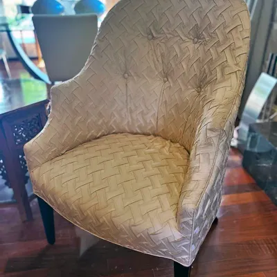 Sale Photo Thumbnail #80: Contemporary accent chair upholstered in a champagne-toned woven basketweave fabric with a tufted back and dark tapered legs.