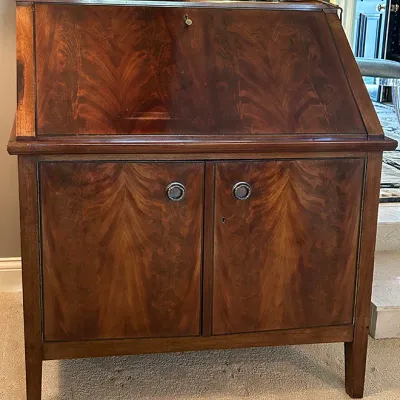 Sale Photo Thumbnail #152: Traditional slant-front secretary desk in dark mahogany finish with book-matched wood grain veneer and lower cabinet storage.
