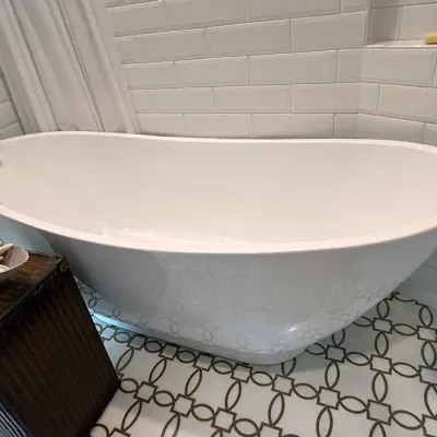 Sale Photo Thumbnail #179: Modern white acrylic freestanding soaking bathtub paired with a wall-mounted brass spout and white subway tile surround.