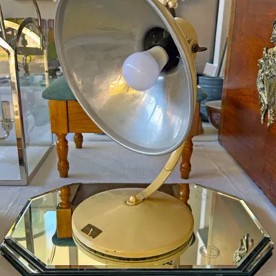 Sale Photo Thumbnail #279: Vintage Rad-A-Ray cream-colored metal heat or desk lamp with an adjustable gooseneck arm, resting on a mirrored octagon tray.