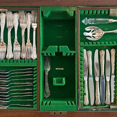 Sale Photo Thumbnail #128: Vintage silver-plated flatware set with ornate handles, arranged inside a green felt-lined wooden canteen chest.