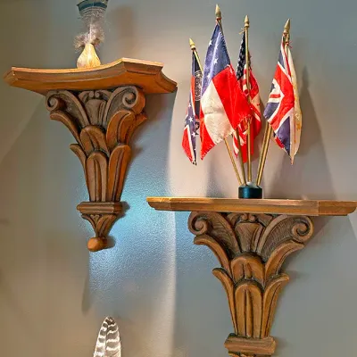 Sale Photo Thumbnail #57: Pair of carved wood acanthus leaf wall corbels featuring decorative displays, including a small flag stand.