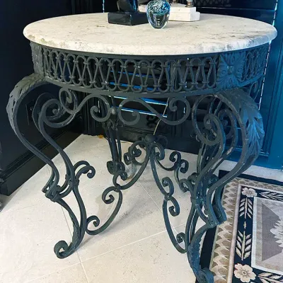 Sale Photo Thumbnail #11: Round wrought iron accent table featuring an ornate scrolled base and a light-colored stone or marble top.