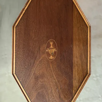 Sale Photo Thumbnail #120: Vintage octagonal wooden tabletop featuring a central urn inlay motif and decorative stringing border.