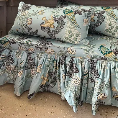 Sale Photo Thumbnail #289: Upholstered bench with matching throw pillows, featuring light blue fabric with a floral and peacock print and a gathered skirt.