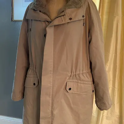 Sale Photo Thumbnail #168: Tan heavy cotton winter parka coat with faux fur lined collar and drawstring waist displayed on a dress form.
