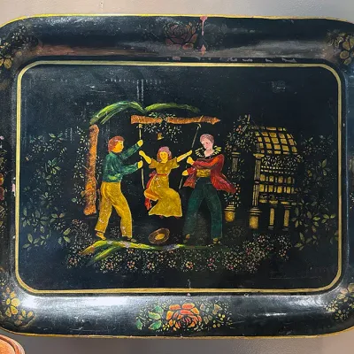 Sale Photo Thumbnail #56: Vintage hand-painted black toleware serving tray featuring figures pushing a child on a swing surrounded by floral borders.