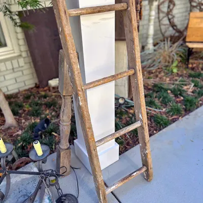 Sale Photo Thumbnail #253: Vintage rustic wooden four-rung ladder with a weathered finish, ideal for display or decorative use.