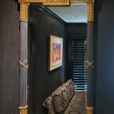 Sale Photo Thumbnail #16: Neoclassical style trumeau-style wall mirror featuring fluted dark side columns, ornate gilded detailing, and an embellished top header block.