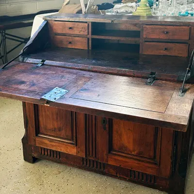 Sale Photo Thumbnail #268: Antique rustic wooden slant-front secretary desk with a drop-down writing surface, small interior drawers, and lower cabinet storage.